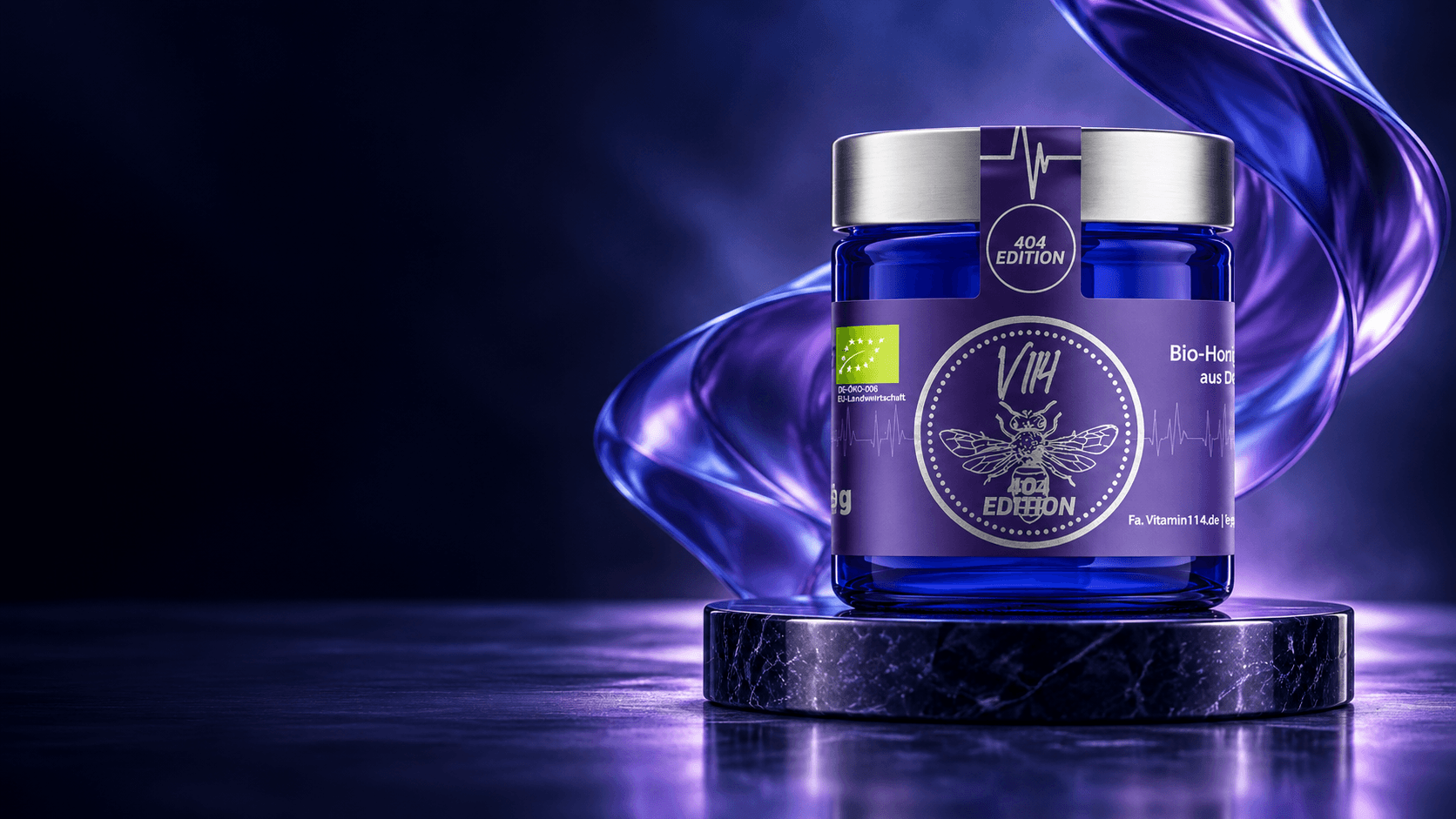 V114 × 404 Edition: blau-violettes Honigglas mit silbernem Deckel auf einem beleuchteten Podest.